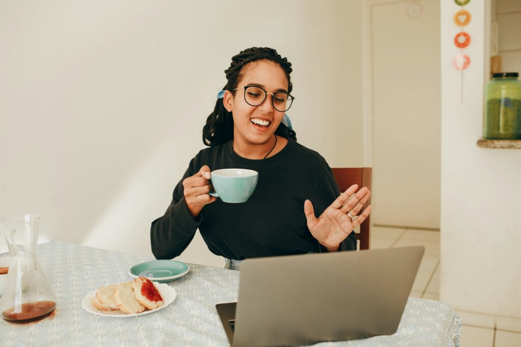 A person laughing while holding a mug of tea